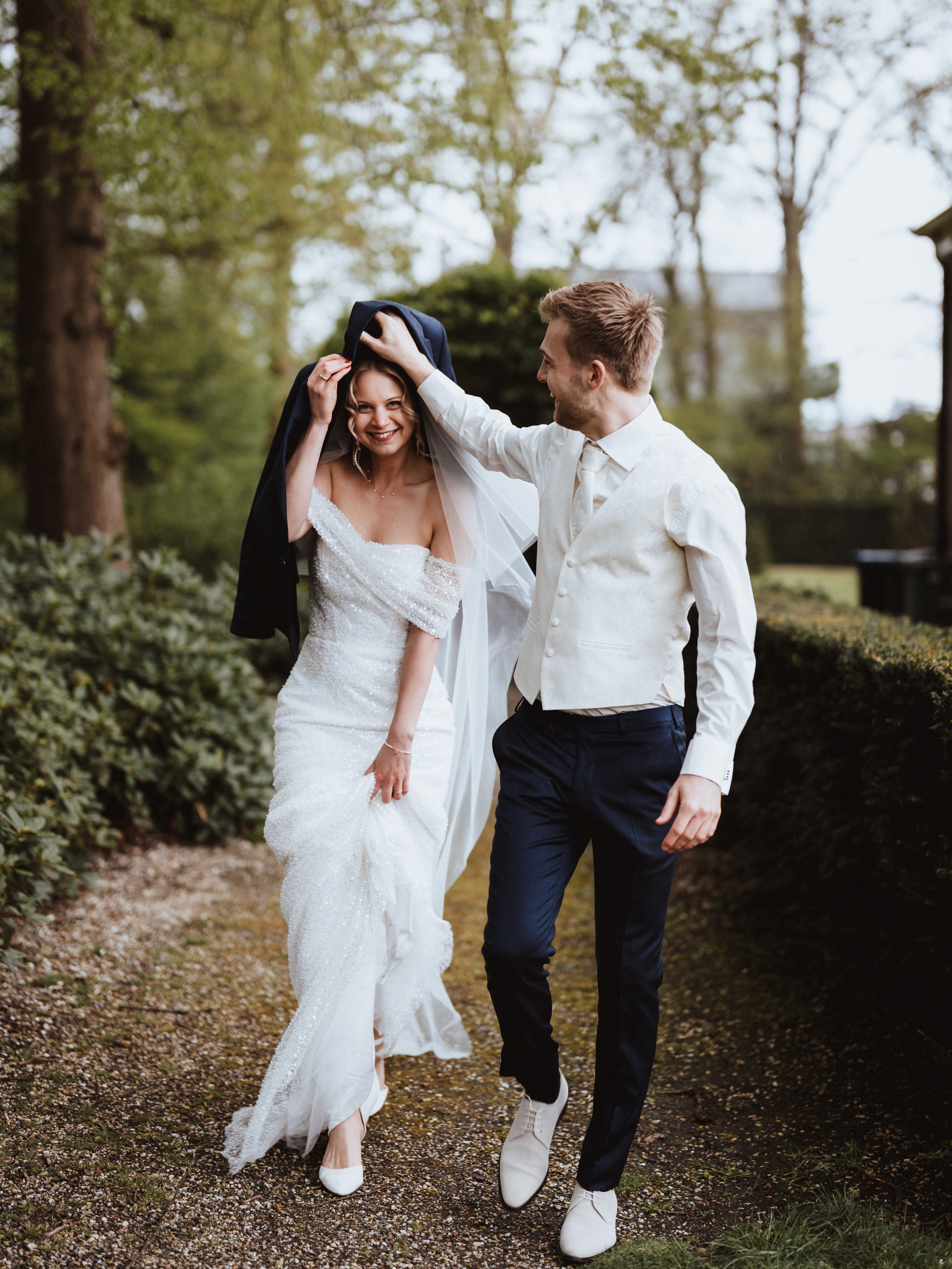 Bruid en bruidegom tijdens een romantisch moment met een paar druppels regen, vastgelegd door Photos by Ville – trouwfotograaf Amersfoort