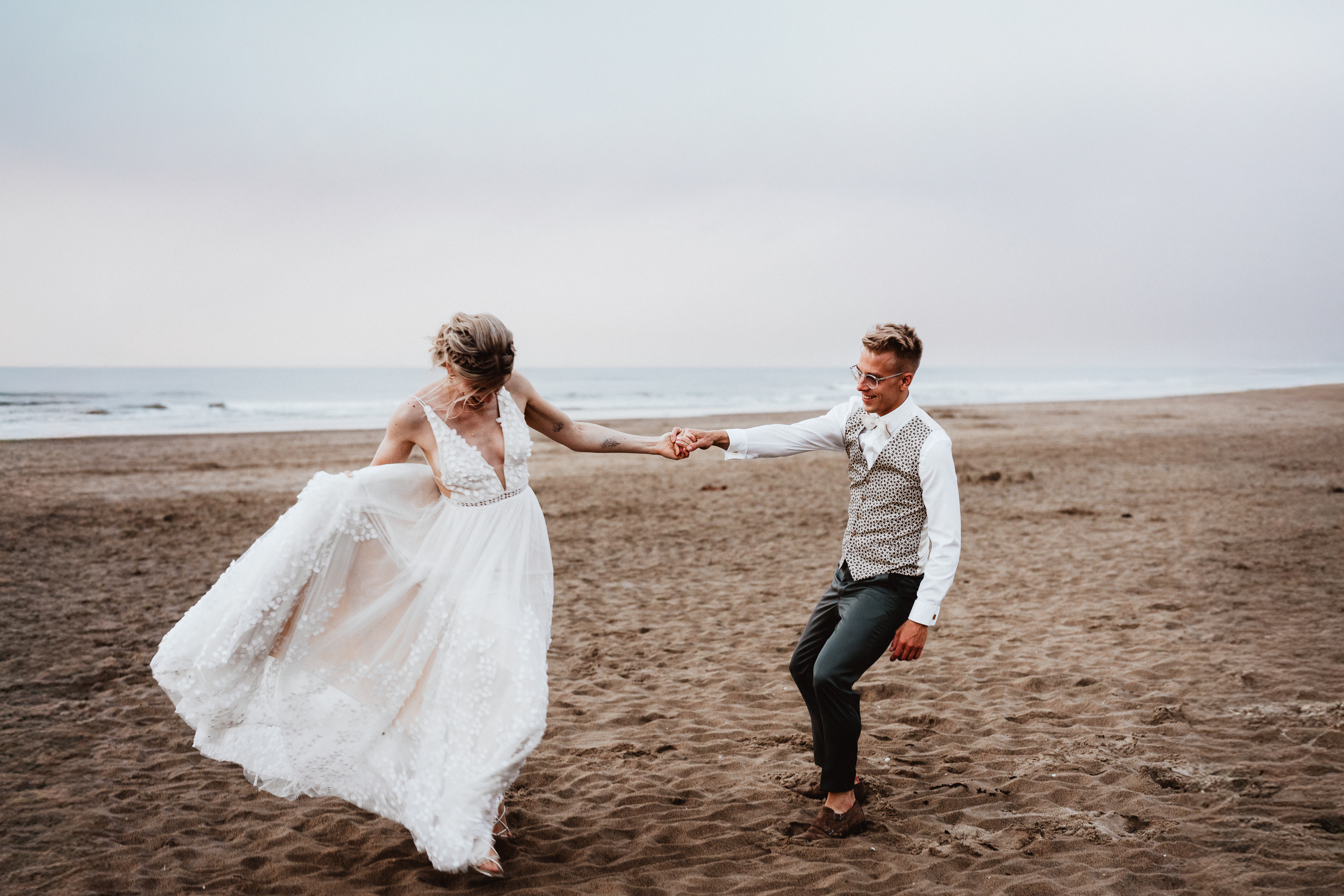 International couple playing and laughing together at sunset on Noordwijk Beach, photographed by Photos by Ville, wedding photographer in the Netherlands for expat and international weddings
