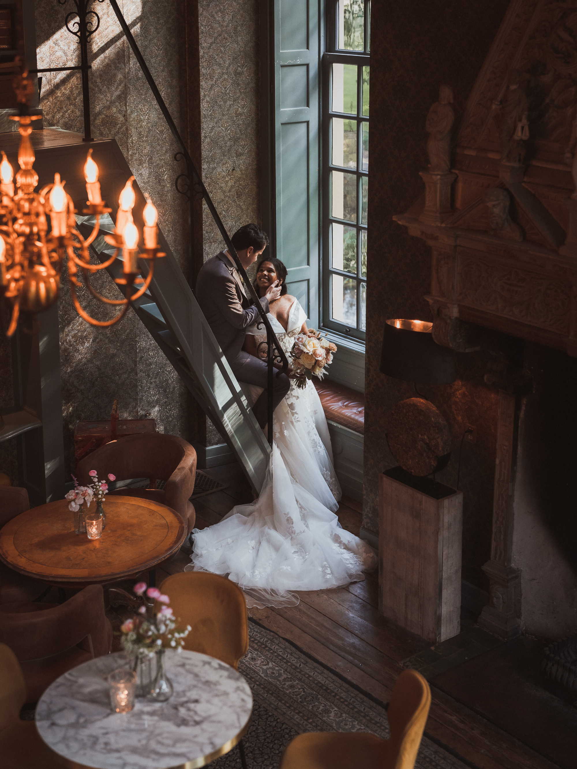 Wedding couple leaning on the stairs inside the library room at Castle Wijenburg, photographed by Photos by Ville, wedding photographer in the Netherlands for international couples