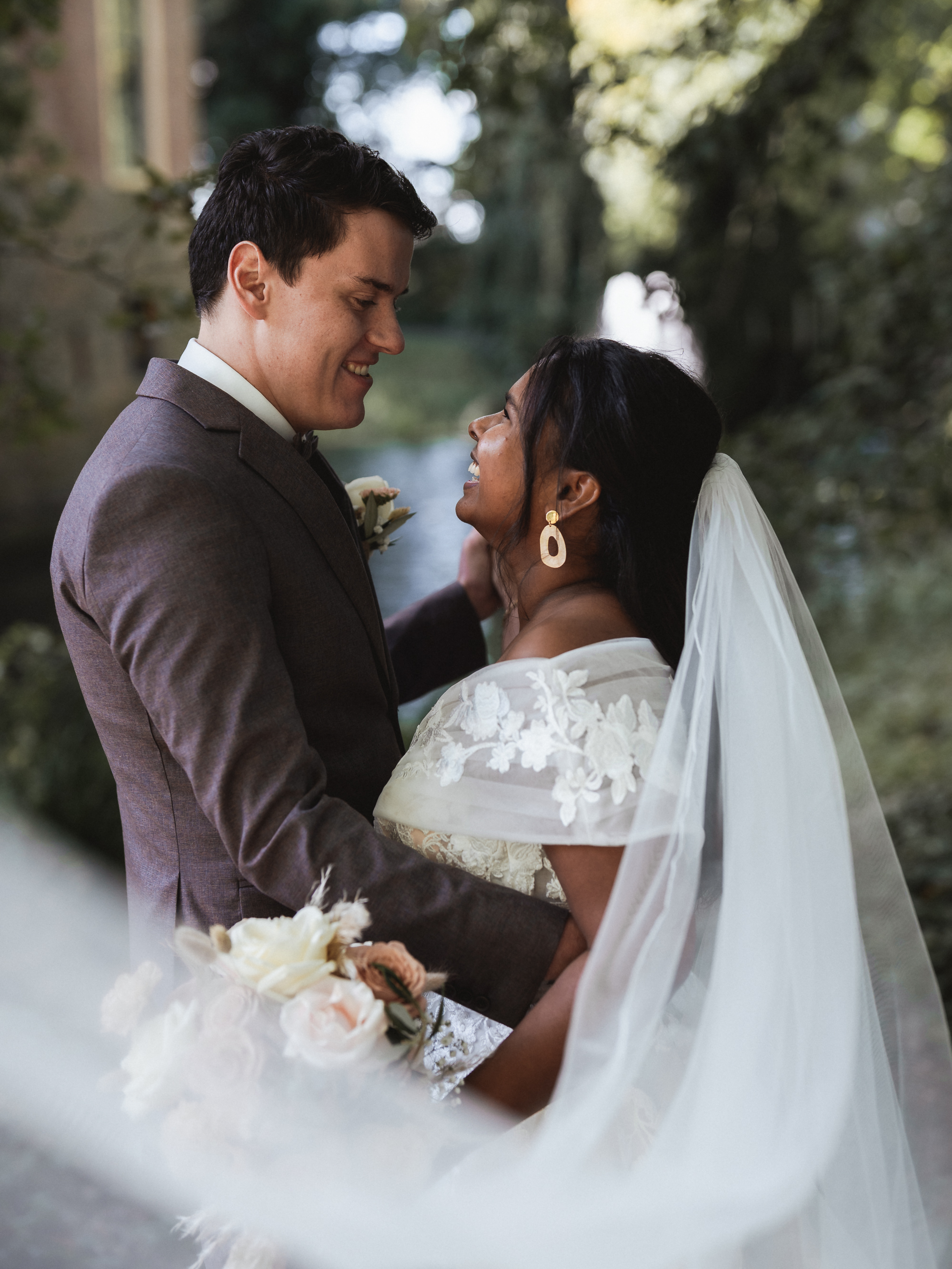 Wedding couple portrait at Castle Wijenburg with the veil creating a soft foreground, photographed by Photos by Ville, wedding photographer in the Netherlands for international couples