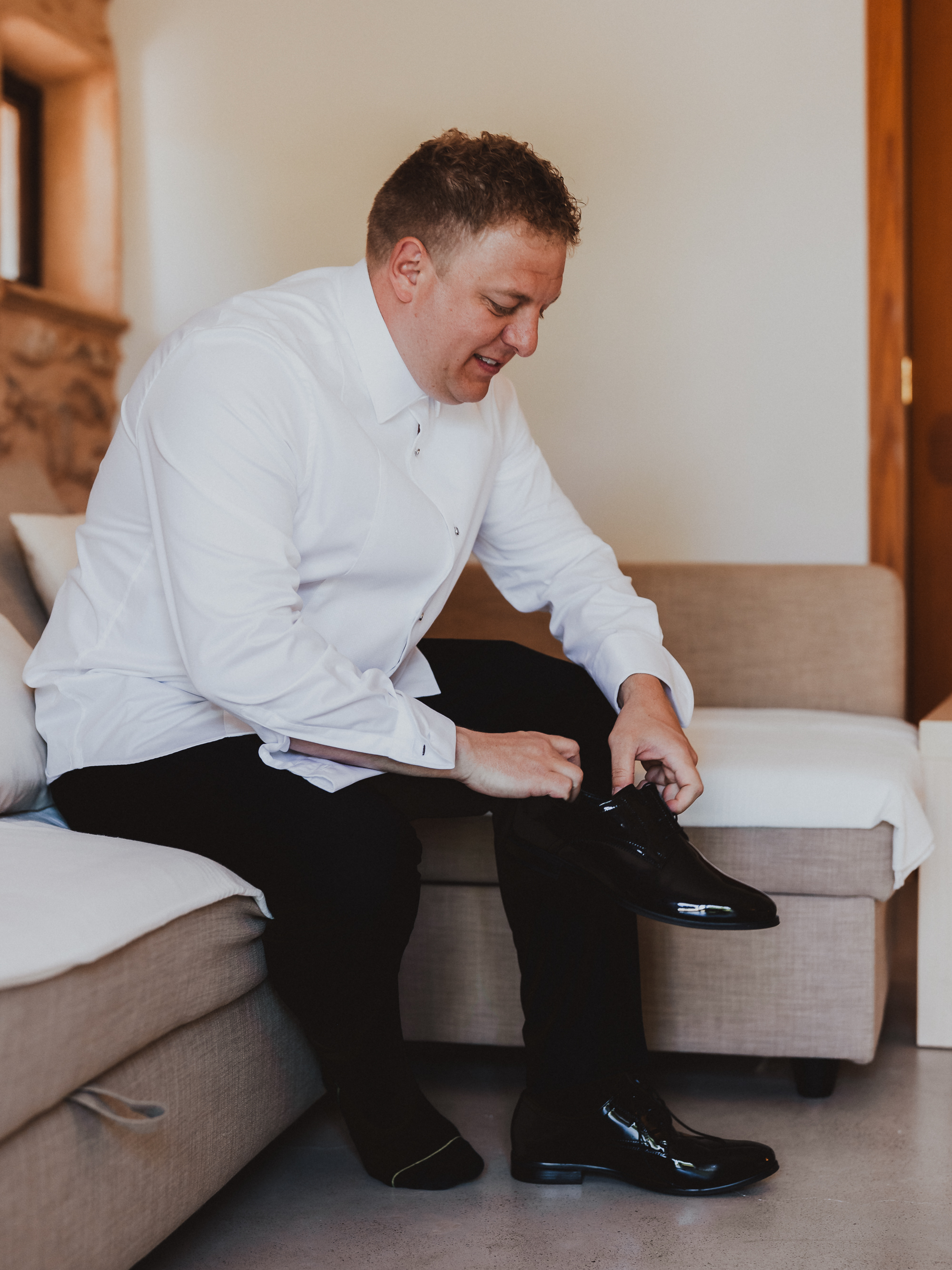 Groom putting on wedding shoes during preparations at a Mallorca finca wedding