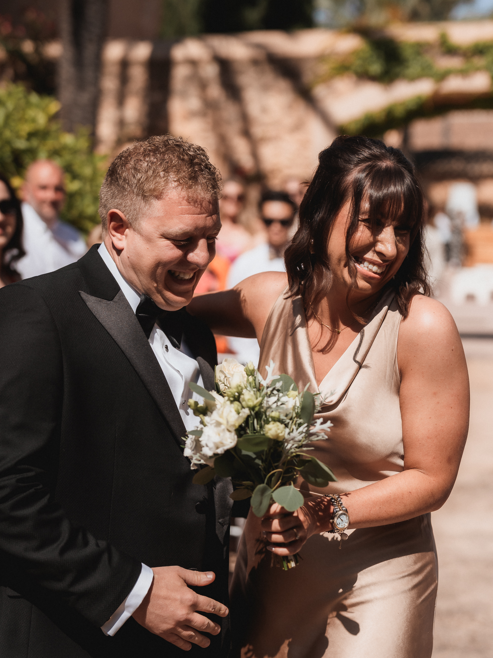 Groom and his sister laughing together during wedding ceremony in Mallorca
