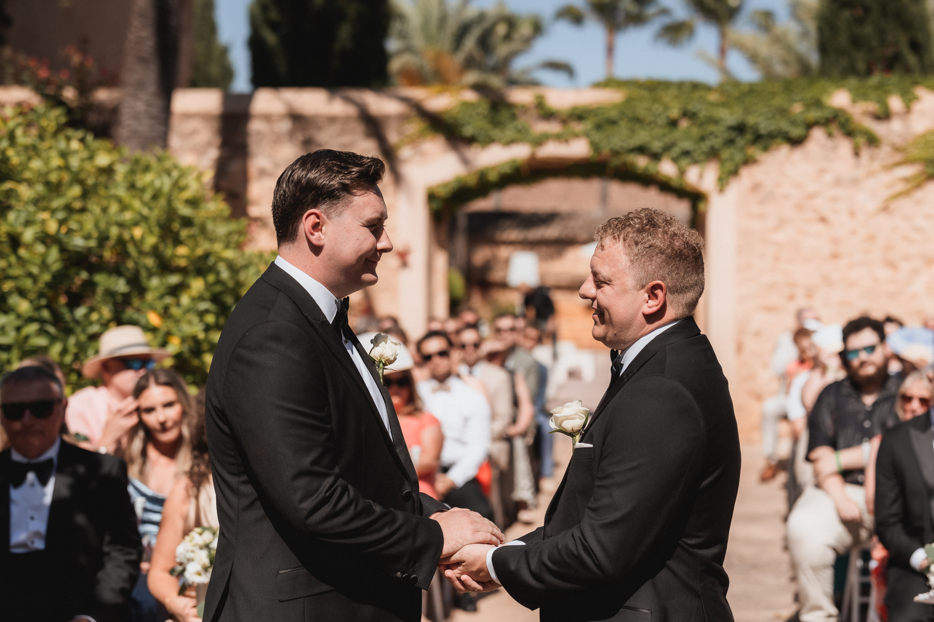 Close-up of two grooms holding hands during wedding ceremony at Finca Son Mir