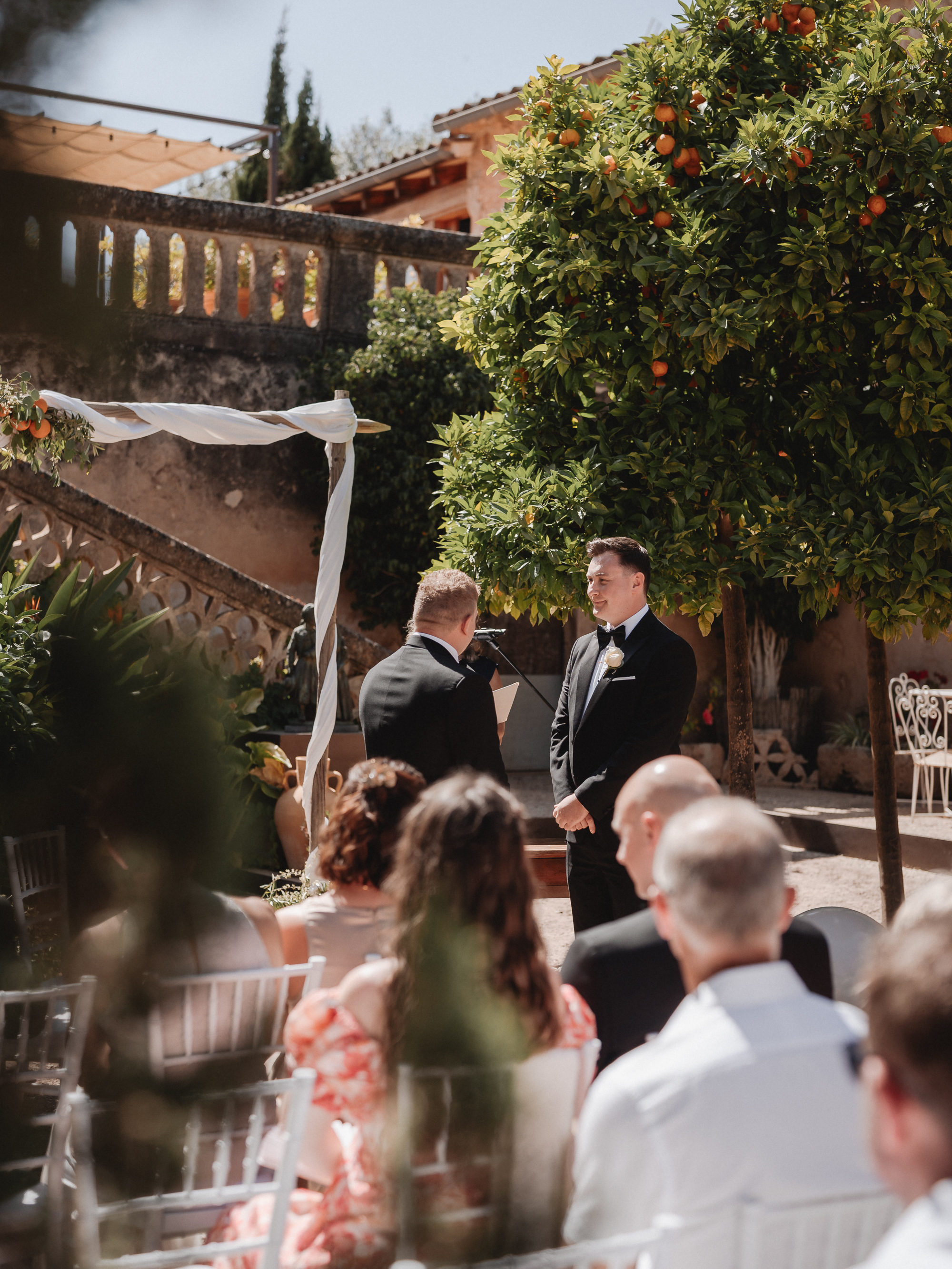 Two grooms looking at each other during their wedding ceremony at Finca Son Mir Mallorca photographed by Photos by Ville