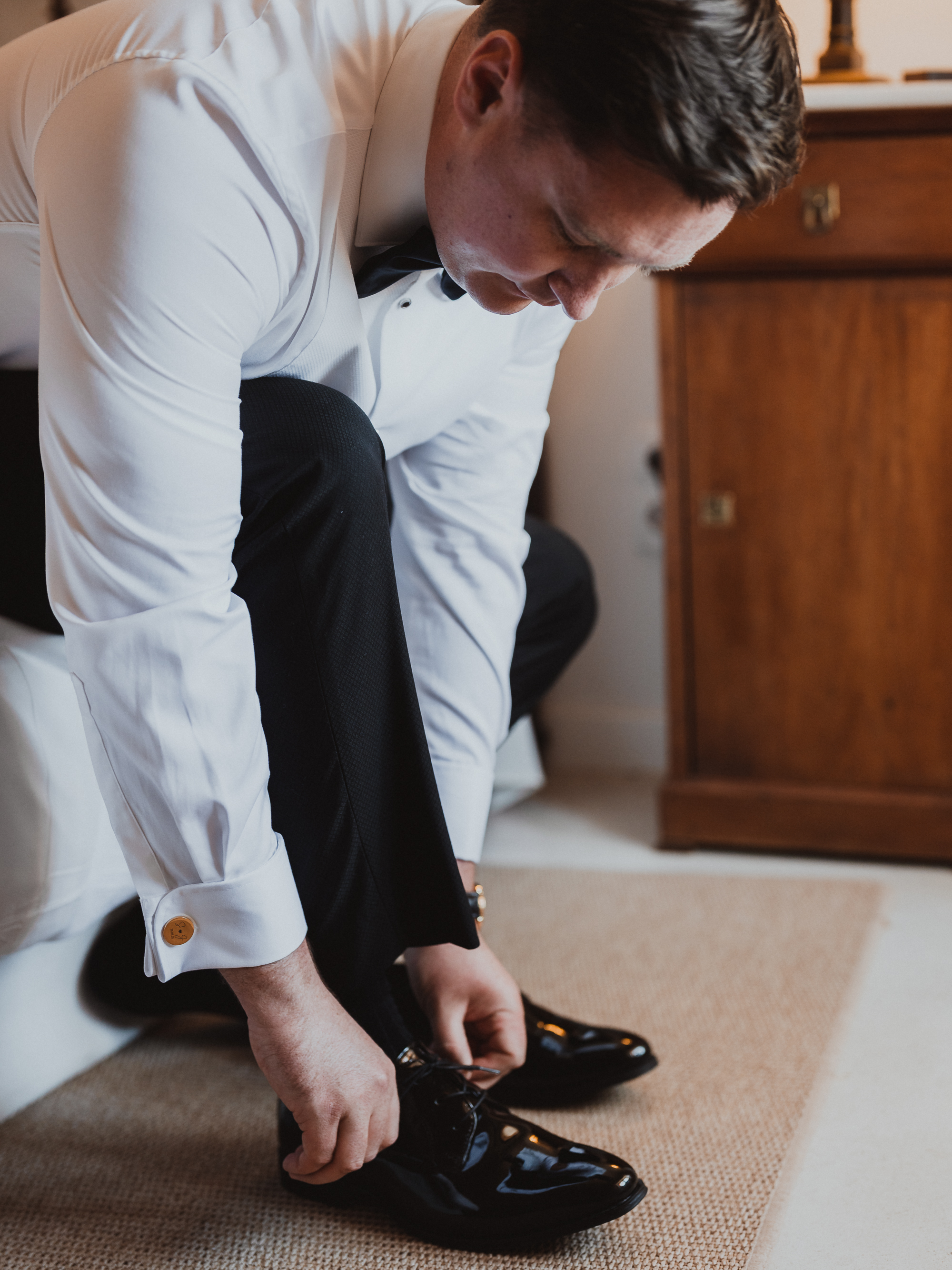 Groom tying shoelaces of his wedding shoes at Finca Son Mir Mallorca