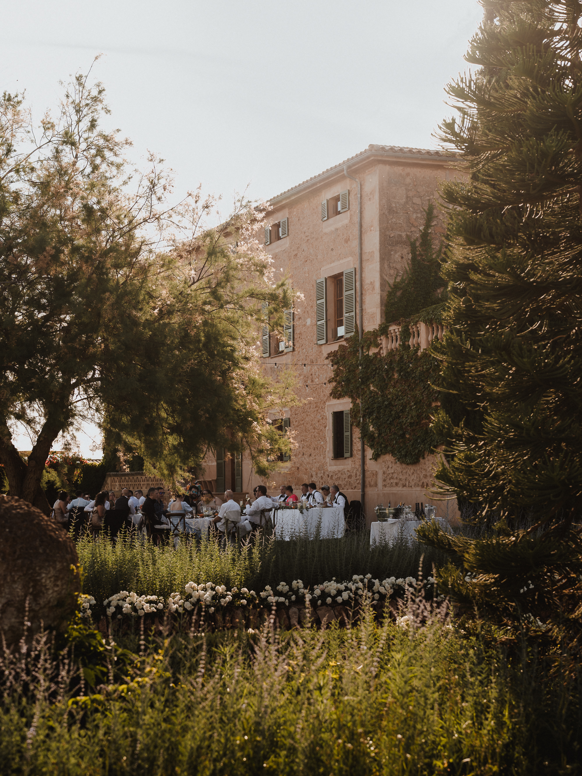 Guests enjoying dinner at Finca Son Mir Mallorca with finca in the background photographed by Photos by Ville